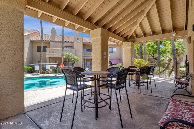 view of patio with a balcony and a community pool