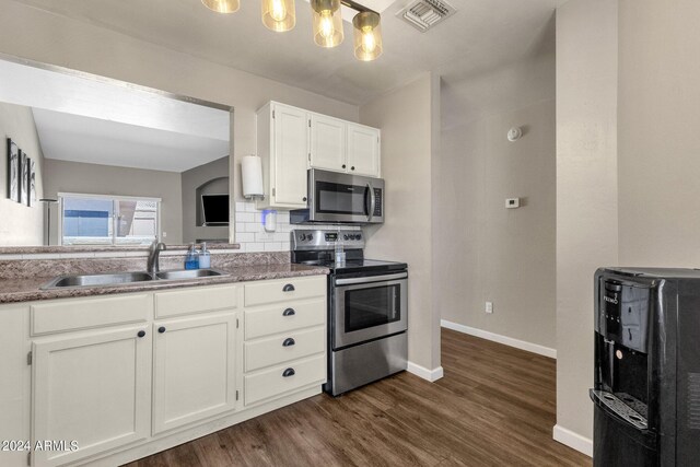 kitchen with sink, dark hardwood / wood-style flooring, decorative backsplash, white cabinetry, and stainless steel appliances