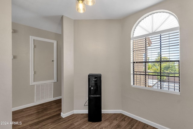 empty room featuring dark wood-style floors, baseboards, and visible vents