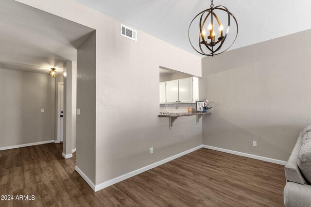 unfurnished living room with dark hardwood / wood-style flooring and a chandelier