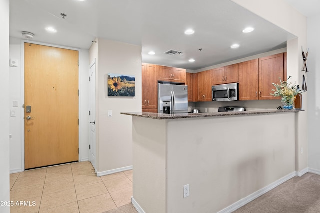 kitchen with stainless steel appliances, recessed lighting, visible vents, light tile patterned flooring, and dark stone countertops