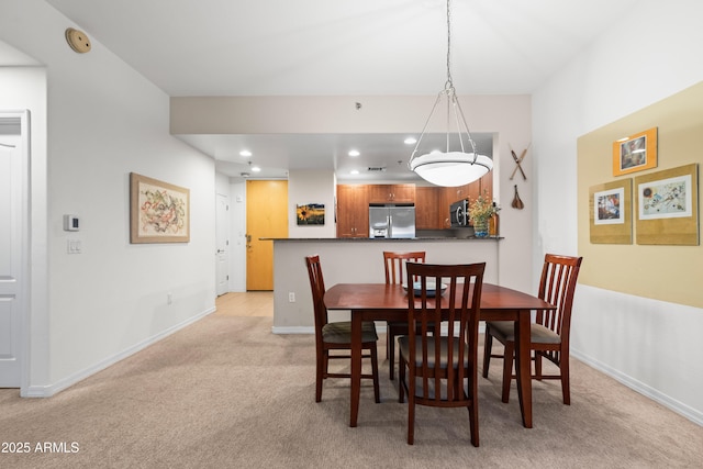 dining room with recessed lighting, light colored carpet, and baseboards