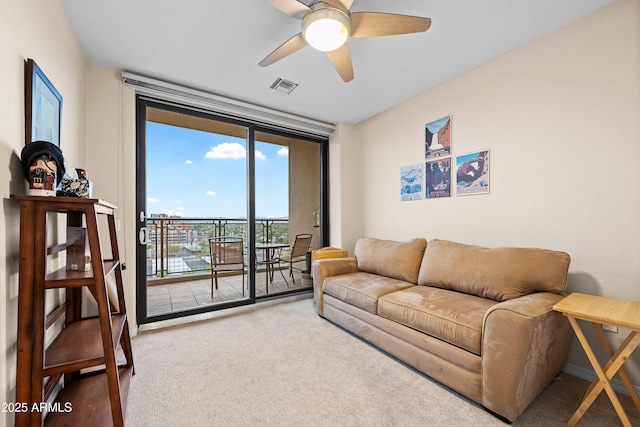 living area featuring ceiling fan, carpet floors, a wall of windows, and visible vents