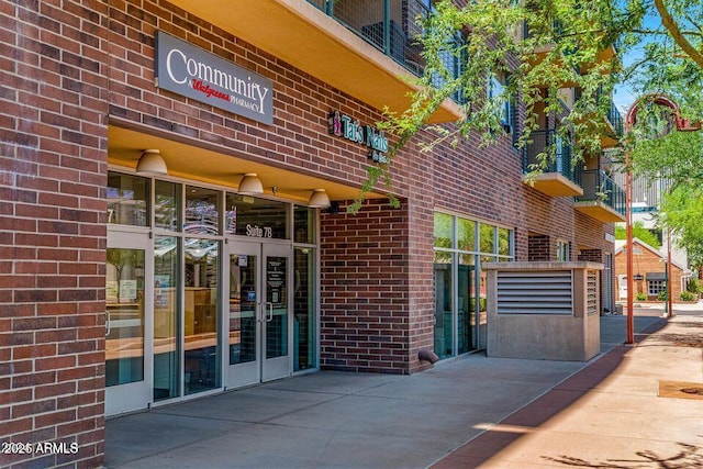 view of exterior entry featuring french doors and brick siding