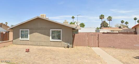 back of property with fence and a gate