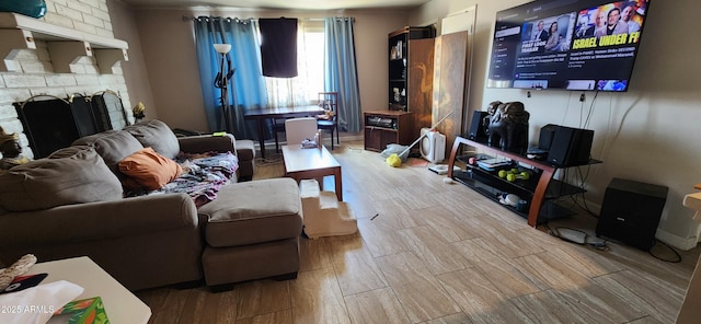 living area with light wood-style floors and a large fireplace