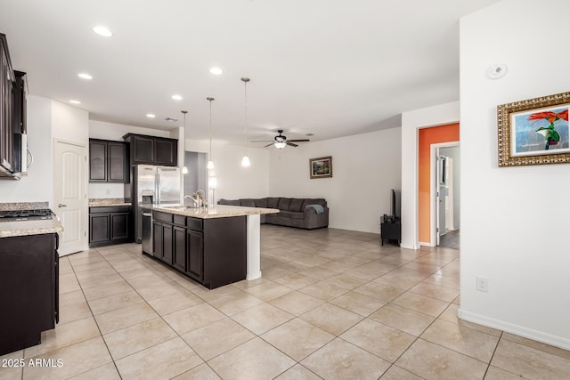 17532 W Copper Ridge Dr, Goodyear, AZ 85338 - kitchen with a ceiling fan, light tile patterned floors, open floor plan, stainless steel appliances, and an island with sink