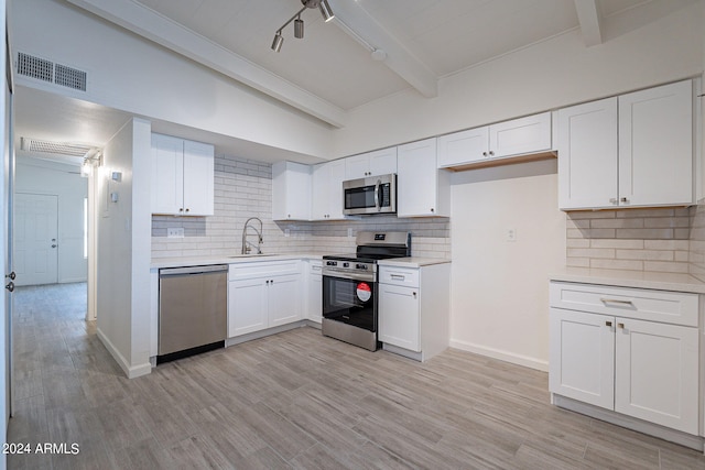 kitchen with white cabinets, light wood-type flooring, stainless steel appliances, beamed ceiling, and sink