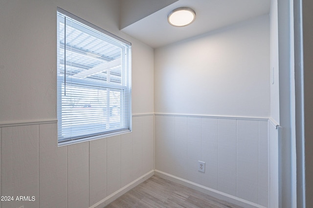 empty room with a wainscoted wall and light wood finished floors