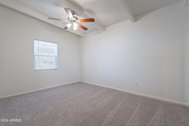 carpeted empty room featuring a ceiling fan, baseboards, and beam ceiling