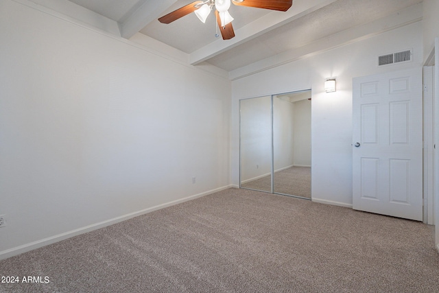 unfurnished bedroom featuring baseboards, visible vents, lofted ceiling with beams, carpet flooring, and a closet