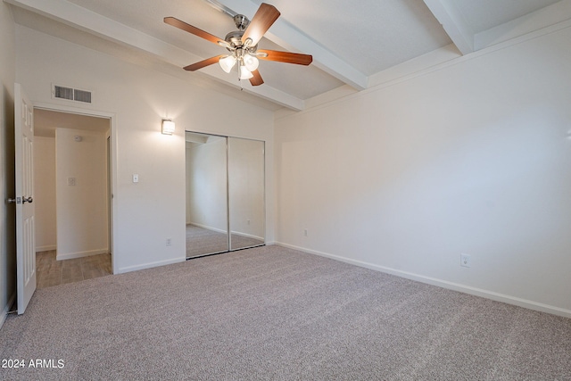 unfurnished bedroom with vaulted ceiling with beams, visible vents, baseboards, a closet, and carpet