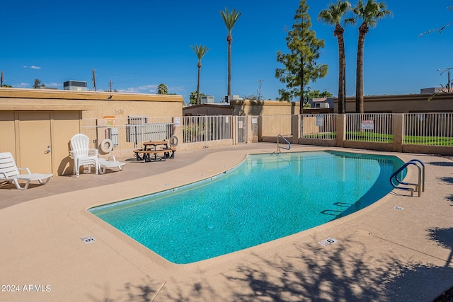 community pool featuring fence and a patio