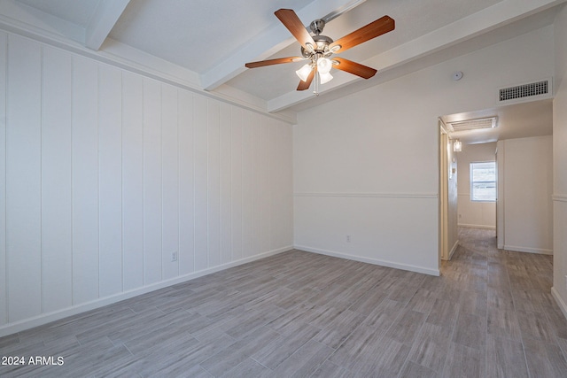 empty room with ceiling fan, visible vents, baseboards, light wood-style floors, and beamed ceiling