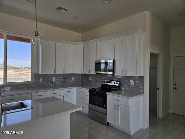 kitchen with visible vents, light countertops, white cabinetry, and stainless steel appliances