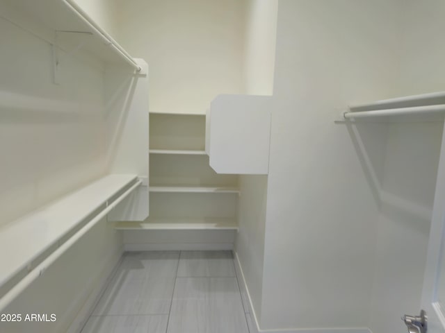 walk in closet with tile patterned flooring