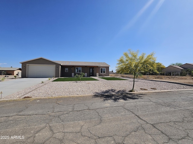 single story home featuring a garage, stucco siding, and concrete driveway