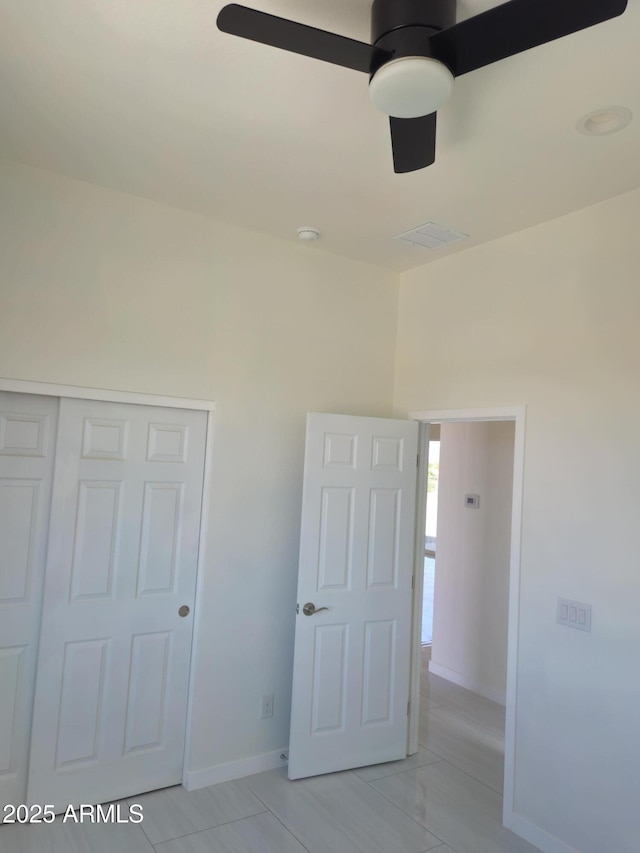 unfurnished bedroom with baseboards, a ceiling fan, visible vents, and a closet