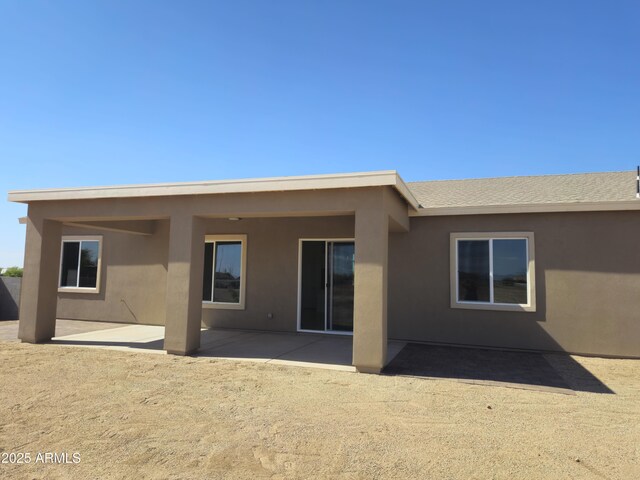 rear view of property featuring stucco siding and a patio area