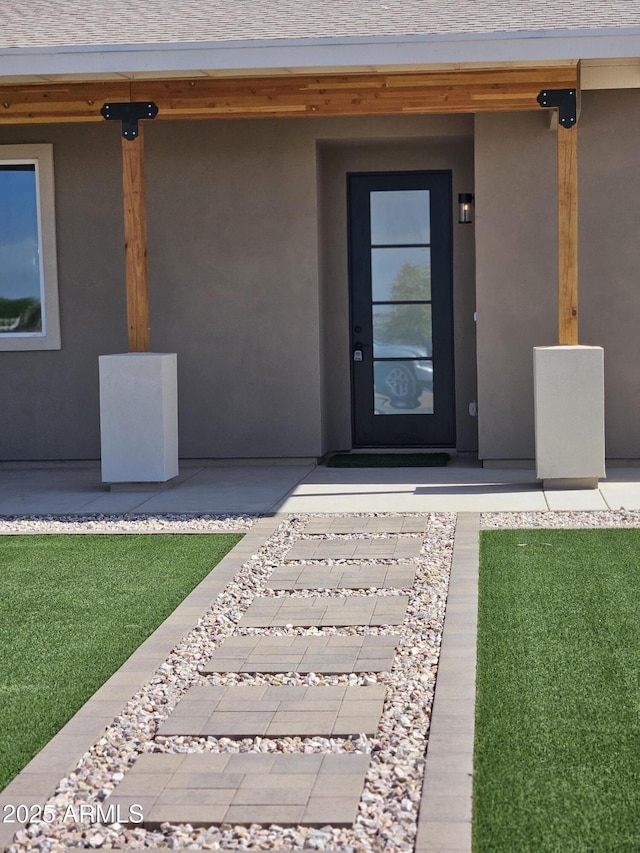 view of exterior entry with stucco siding