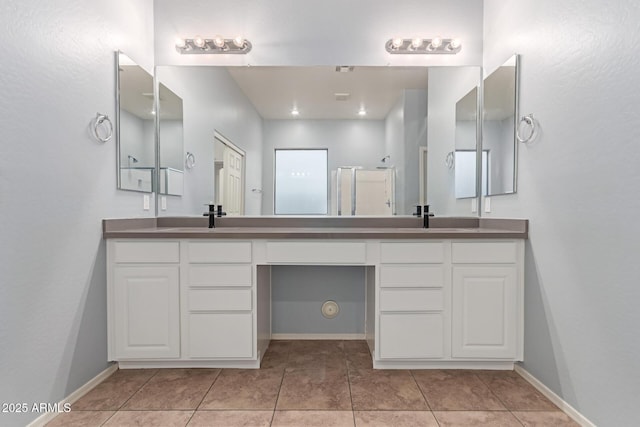 bathroom with tile patterned flooring, vanity, and a shower with shower door