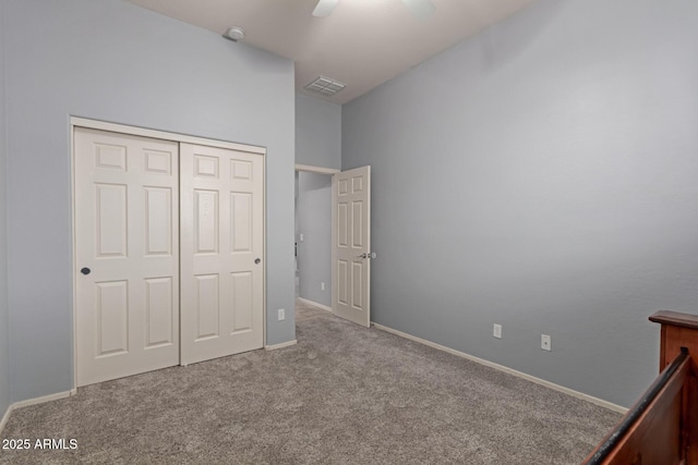 unfurnished bedroom featuring carpet flooring, ceiling fan, and a closet