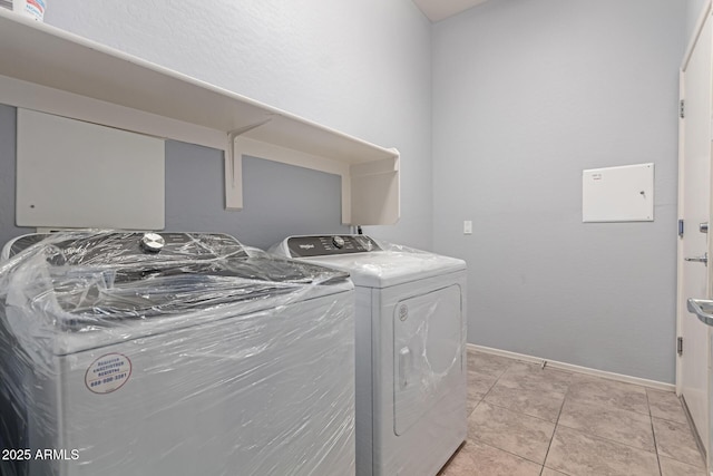 washroom with light tile patterned floors and washer and dryer