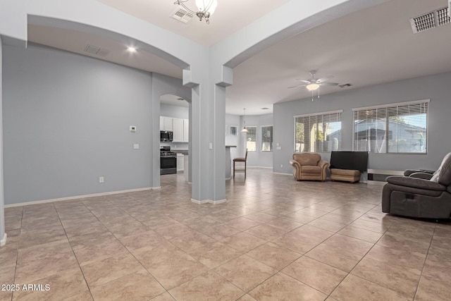 living room featuring light tile patterned floors and ceiling fan with notable chandelier