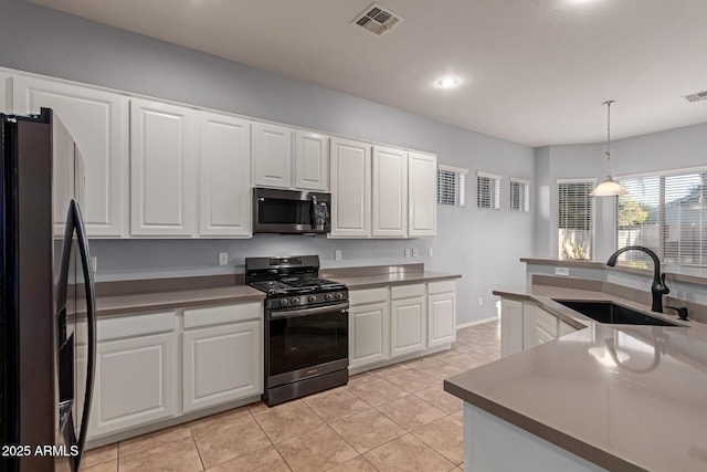 kitchen with white cabinets, sink, hanging light fixtures, light tile patterned floors, and stainless steel appliances