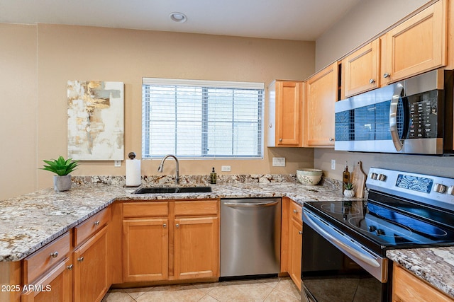 kitchen featuring light tile patterned flooring, appliances with stainless steel finishes, sink, and light stone countertops