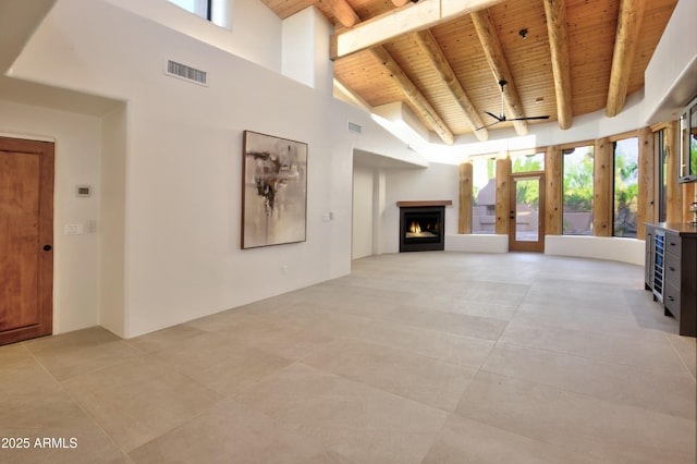 1637 N Quartz Valley Rd, Scottsdale, AZ 85266 - unfurnished living room with a wooden ceiling with exposed beams, high vaulted ceiling, plenty of natural light, and a warm lit fireplace