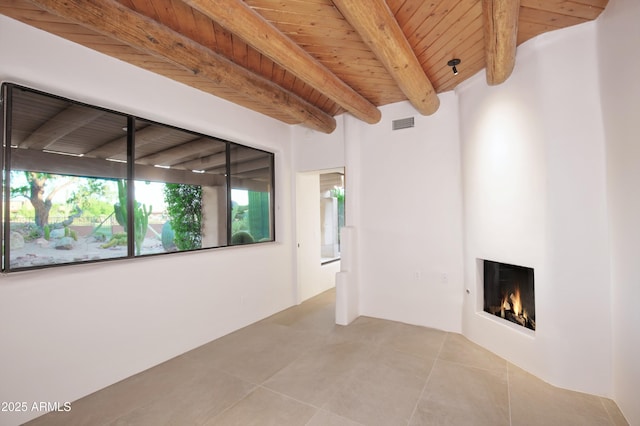 1637 N Quartz Valley Rd, Scottsdale, AZ 85266 - unfurnished room with a wood ceiling with exposed beams, tile patterned flooring, and a large fireplace