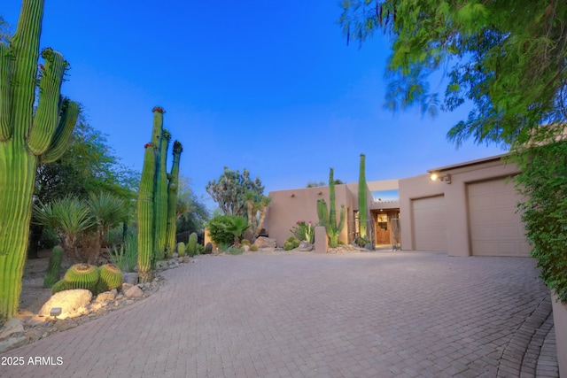 1637 N Quartz Valley Rd, Scottsdale, AZ 85266 - pueblo revival-style home featuring stucco siding, an attached garage, and driveway