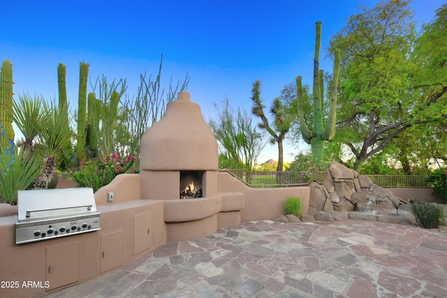 1637 N Quartz Valley Rd, Scottsdale, AZ 85266 - view of patio with a warm lit fireplace and an outdoor kitchen