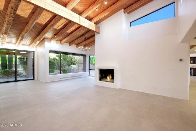 1637 N Quartz Valley Rd, Scottsdale, AZ 85266 - unfurnished living room with a wooden ceiling with exposed beams, a lit fireplace, plenty of natural light, a towering ceiling, and tile patterned floors