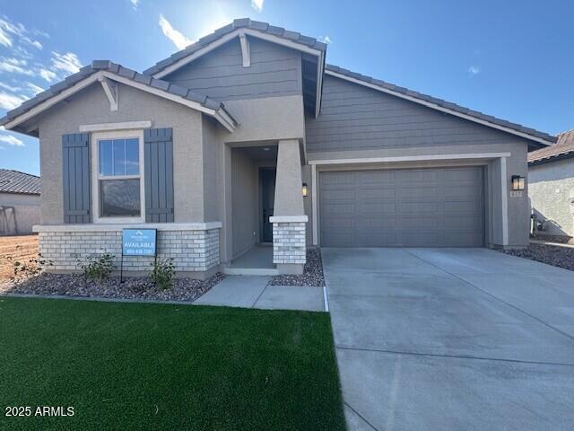 view of front of home with a garage, concrete driveway, a tiled roof, stucco siding, and a front lawn