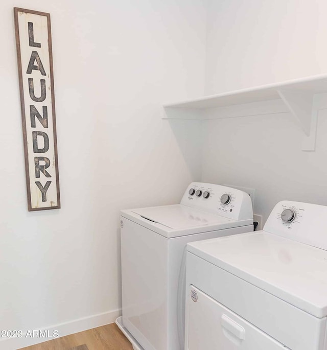 washroom with laundry area, light wood-style floors, independent washer and dryer, and baseboards