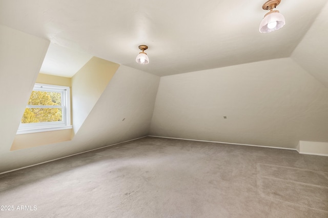 bonus room with lofted ceiling and carpet flooring