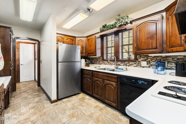 kitchen with light countertops, a sink, freestanding refrigerator, dishwasher, and decorative backsplash