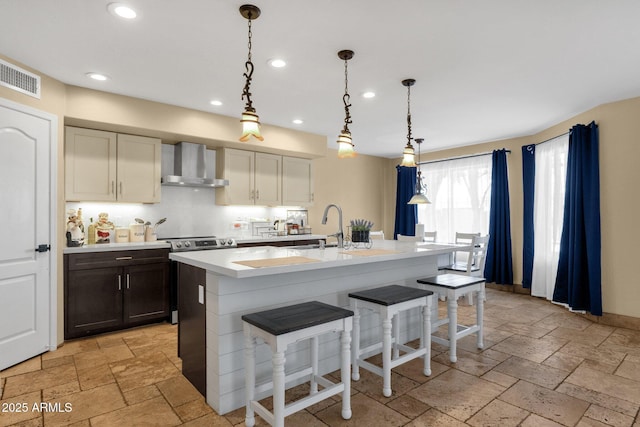 508 W San Angelo St, Gilbert, AZ 85233 - kitchen featuring wall chimney exhaust hood, a sink, recessed lighting, light countertops, and a kitchen breakfast bar