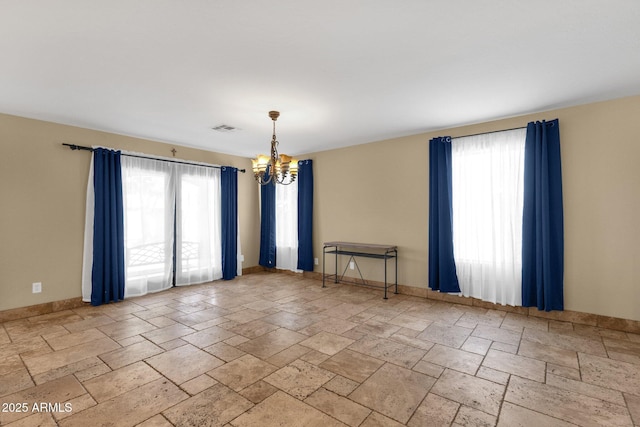 508 W San Angelo St, Gilbert, AZ 85233 - empty room featuring a chandelier, plenty of natural light, and stone tile floors