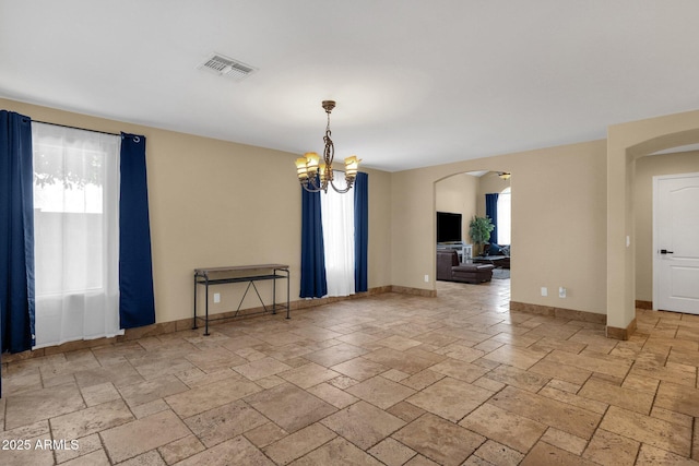 508 W San Angelo St, Gilbert, AZ 85233 - spare room featuring arched walkways, plenty of natural light, and stone tile floors