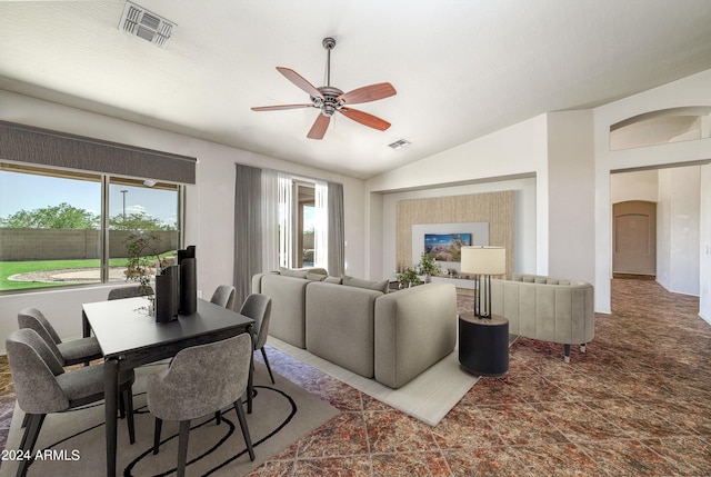 living room featuring a ceiling fan, arched walkways, visible vents, and vaulted ceiling