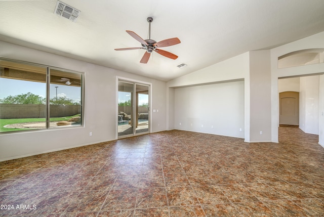 spare room featuring a ceiling fan, lofted ceiling, visible vents, and arched walkways