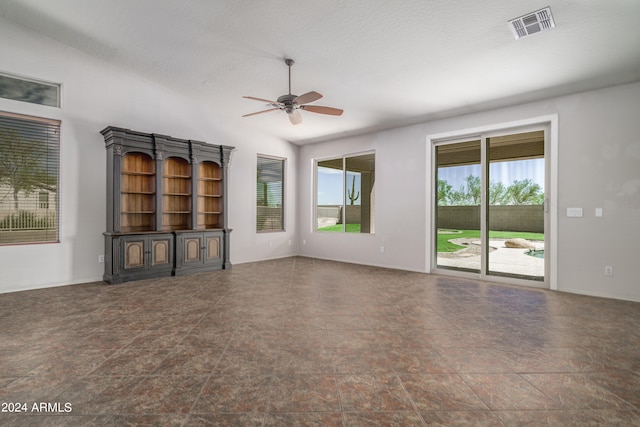 unfurnished living room featuring lofted ceiling, visible vents, ceiling fan, and a textured ceiling