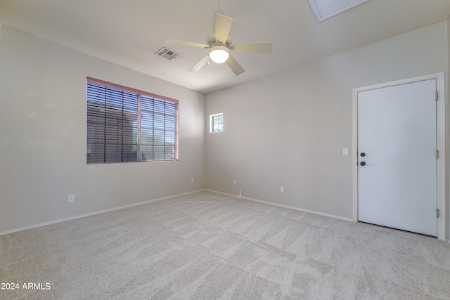 empty room featuring ceiling fan, carpet floors, and visible vents