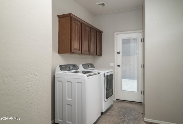 washroom with cabinet space, baseboards, visible vents, tile patterned floors, and separate washer and dryer