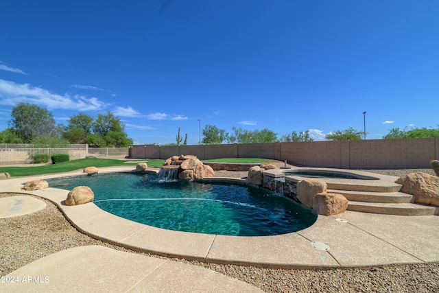 view of swimming pool featuring a fenced backyard and a pool with connected hot tub