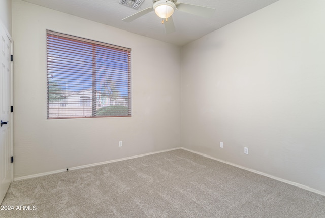 empty room featuring ceiling fan, carpet, visible vents, and baseboards