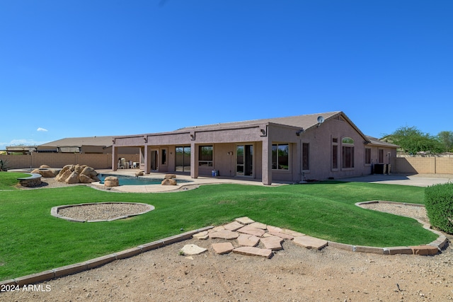 rear view of house with a patio area, a yard, a fenced backyard, and stucco siding